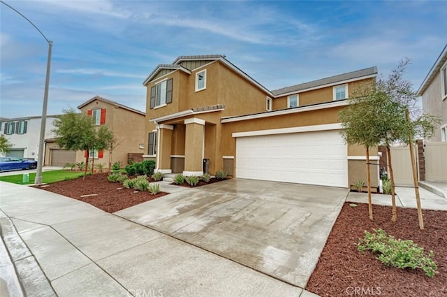 traditional-style house featuring stucco siding, concrete driveway, and fence