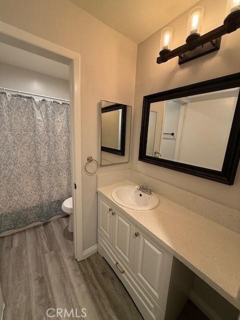 20234 Cantara St Unit 143, Winnetka, CA 91306 - bathroom with wood finished floors, vanity, and a shower with shower curtain