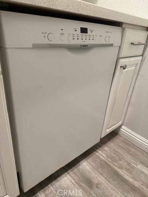 20234 Cantara St Unit 143, Winnetka, CA 91306 - kitchen view of dishwasher, wood finished floors, and white cabinets