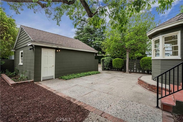 view of patio featuring fence and an outbuilding