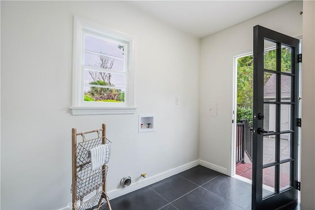washroom with washer hookup, baseboards, dark tile patterned floors, hookup for an electric dryer, and hookup for a gas dryer