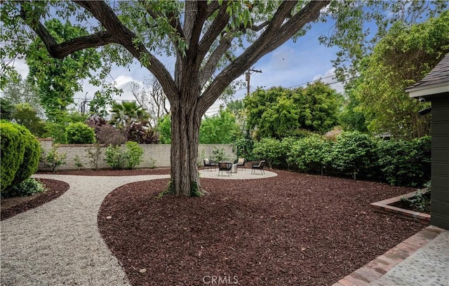 fenced yard featuring a patio area and an outdoor fire pit
