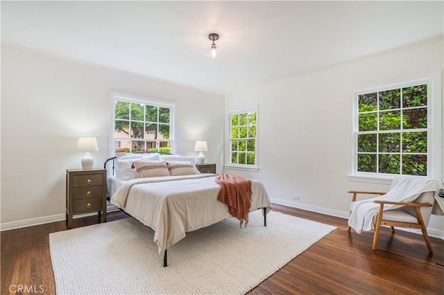 bedroom with baseboards and dark wood-style flooring