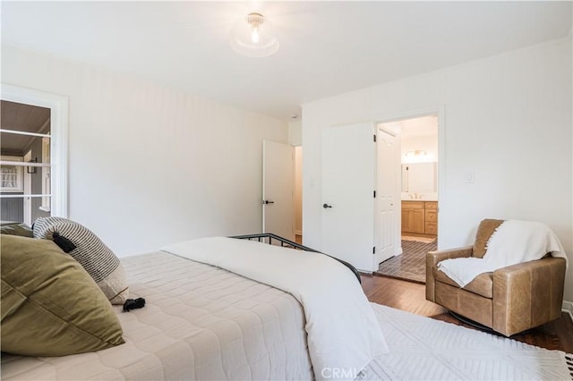 bedroom featuring wood finished floors and connected bathroom