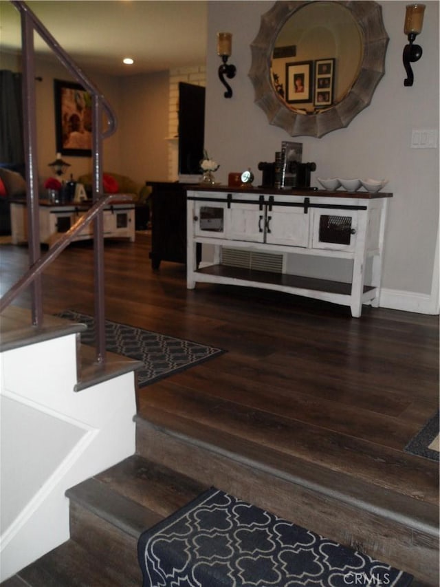 stairs featuring wood finished floors, baseboards, and recessed lighting