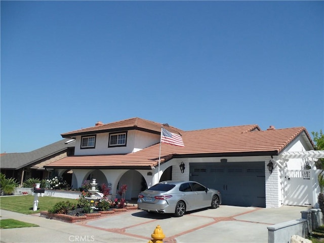 view of front of home featuring a garage, concrete driveway, stucco siding, and a tile roof