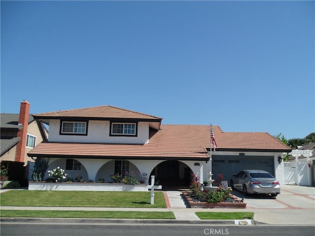 view of front facade featuring a garage, stucco siding, a tiled roof, and driveway