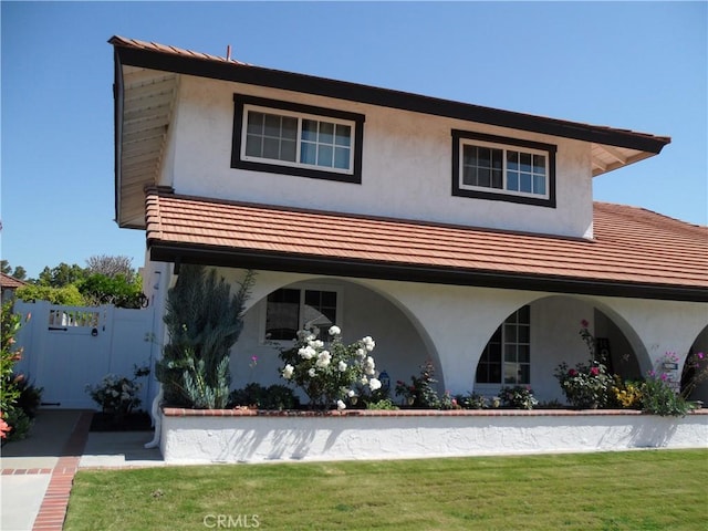 view of front of house with stucco siding and a gate