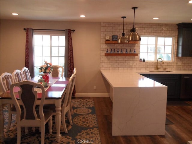 kitchen with a sink, plenty of natural light, light countertops, dark wood-style flooring, and recessed lighting