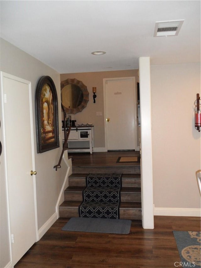 staircase with wood finished floors, baseboards, and recessed lighting