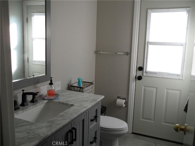 half bathroom with vanity and toilet
