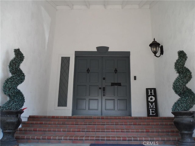 property entrance with stucco siding