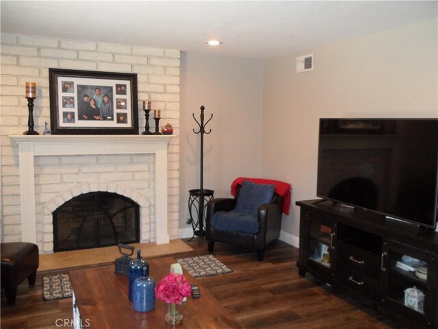living area with a fireplace, wood finished floors, baseboards, and recessed lighting