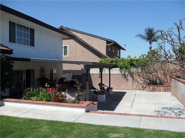 view of home's exterior featuring a patio area, fence, and stucco siding