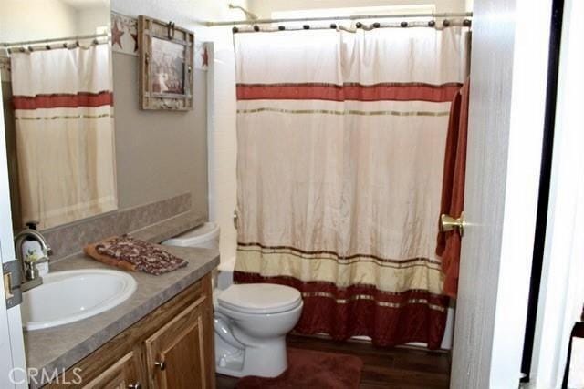 36072 Meadow Grove Rd, Yermo, CA 92398 - bathroom with vanity, toilet, wood finished floors, and a shower with curtain