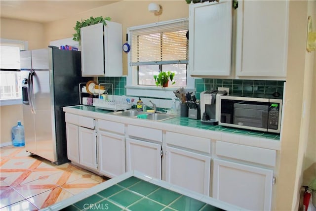 837 W 103rd St, Los Angeles, CA 90044 - kitchen with black microwave, a sink, backsplash, and white cabinetry