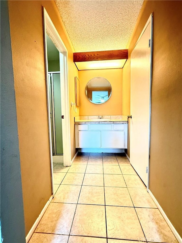 18122 Sundowner Way Unit 1108, Canyon Country, CA 91387 - hallway with light tile patterned flooring, a textured ceiling, and baseboards