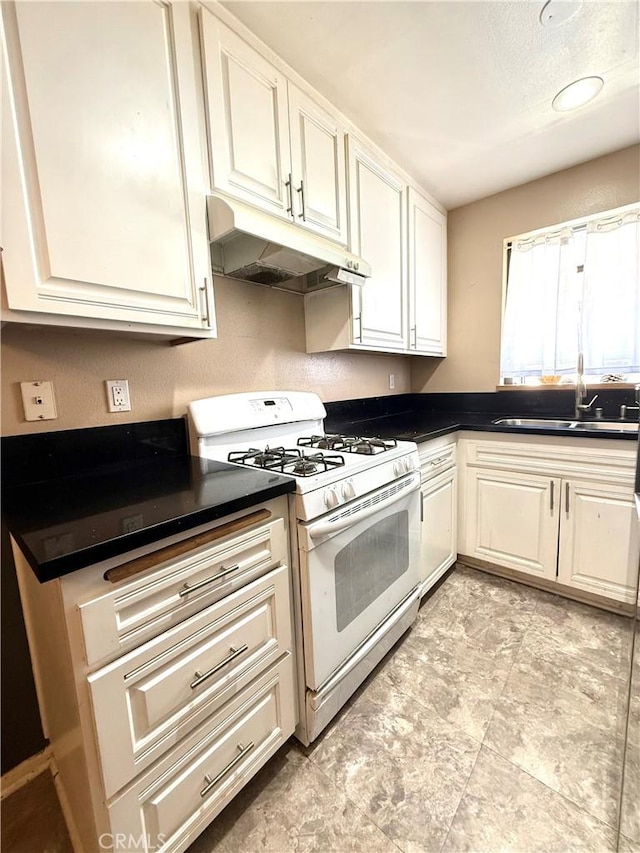 18122 Sundowner Way Unit 1108, Canyon Country, CA 91387 - kitchen with under cabinet range hood, white gas range oven, a sink, dark countertops, and white cabinets