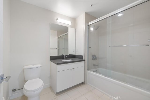 bathroom with tile patterned flooring, vanity, toilet, and shower / bath combination with glass door
