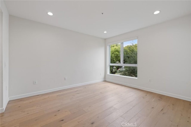 spare room with light wood finished floors, baseboards, and recessed lighting