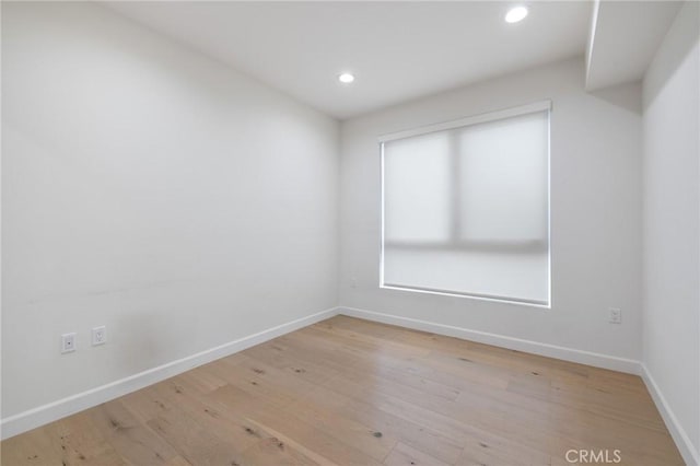 unfurnished room with baseboards, recessed lighting, and light wood-style floors
