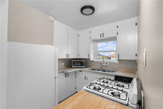 540 Avalon St, Morro Bay, CA 93442 - kitchen with white appliances, a sink, light countertops, and white cabinets