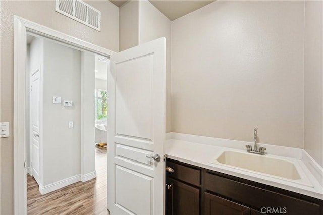 bathroom with wood finished floors, baseboards, and vanity