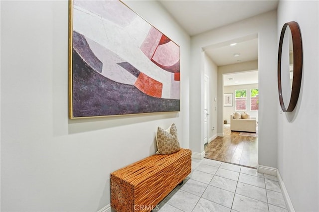 hallway featuring tile patterned floors and baseboards
