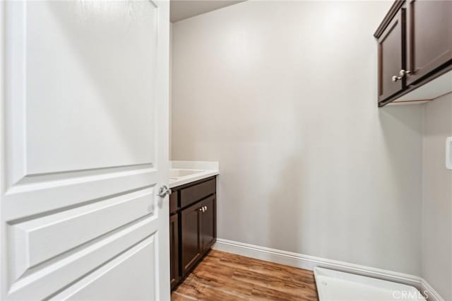 laundry room featuring light wood-type flooring and baseboards