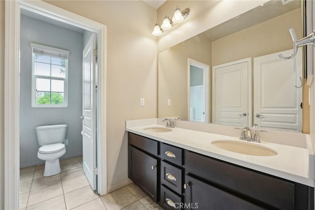 bathroom with double vanity, tile patterned floors, toilet, and baseboards