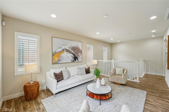 living area featuring wood finished floors, baseboards, and recessed lighting