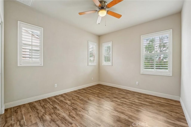 spare room with wood finished floors, baseboards, and ceiling fan