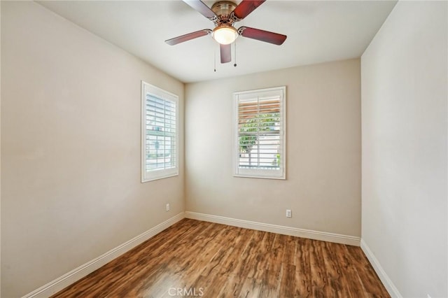 unfurnished room with wood finished floors, baseboards, and a ceiling fan