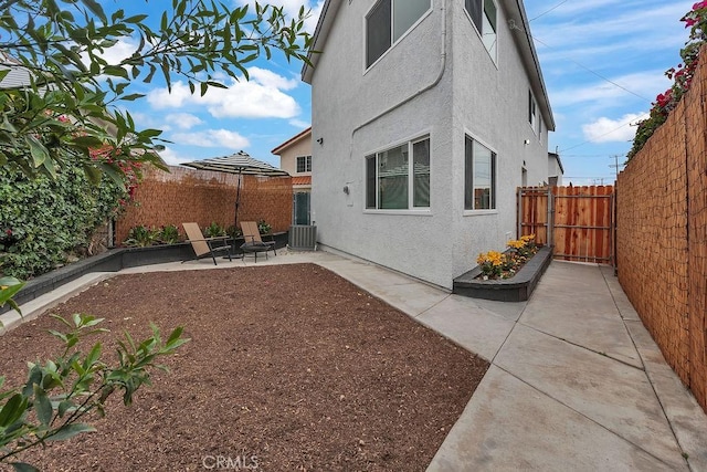 view of home's exterior with stucco siding, a patio, a fenced backyard, and cooling unit