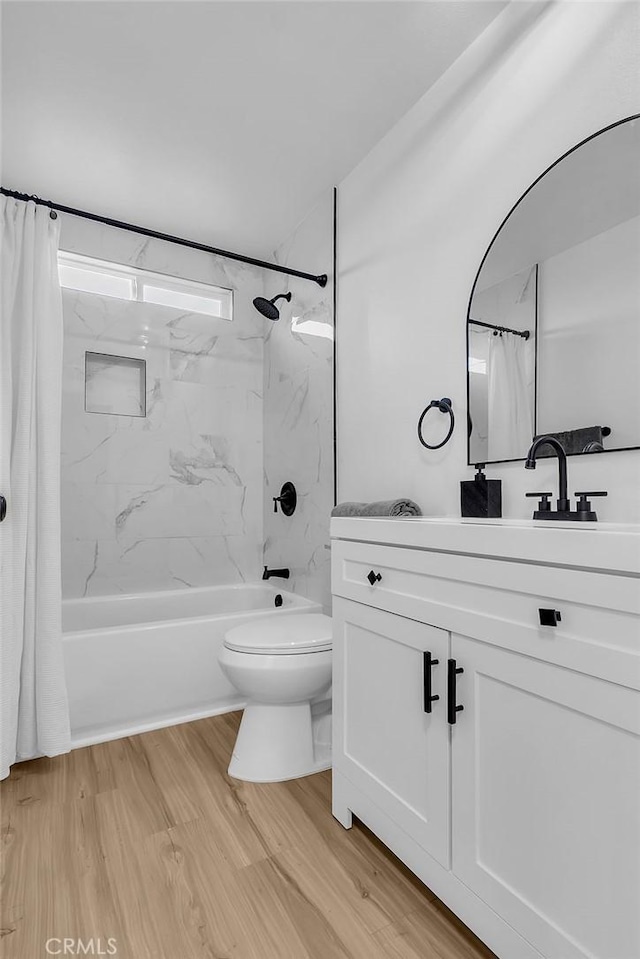 bathroom featuring shower / bath combination with curtain, vanity, wood finished floors, and toilet