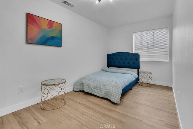 bedroom with baseboards and wood finished floors