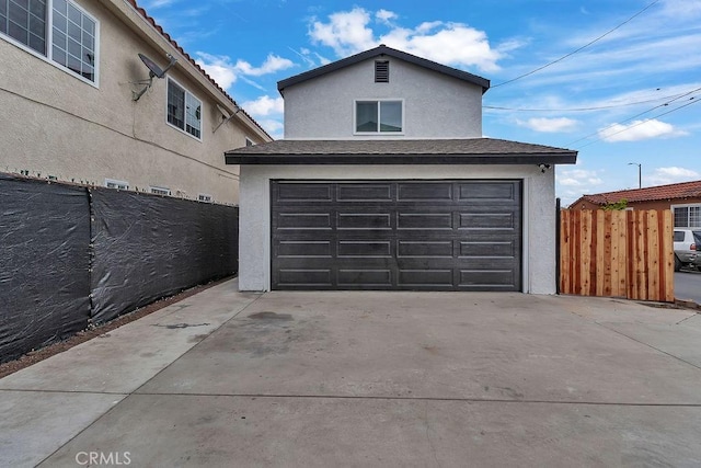 garage with driveway and fence