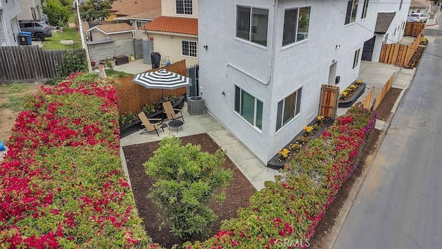 view of home's exterior featuring stucco siding, a fenced backyard, a patio, and central AC
