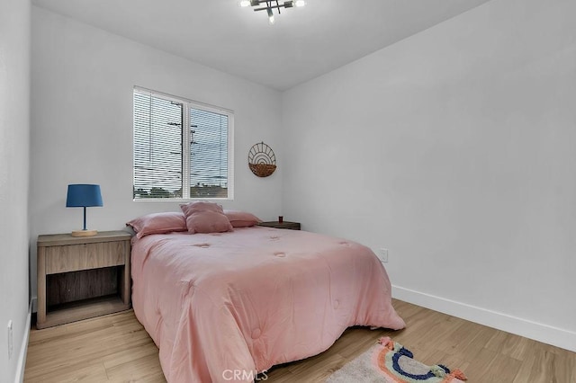 bedroom featuring baseboards and light wood finished floors