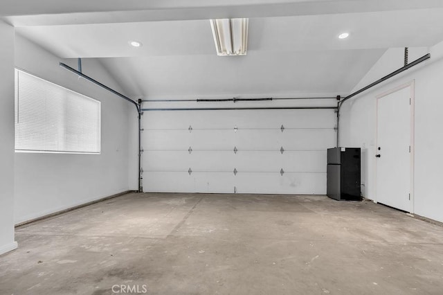 garage with freestanding refrigerator and recessed lighting
