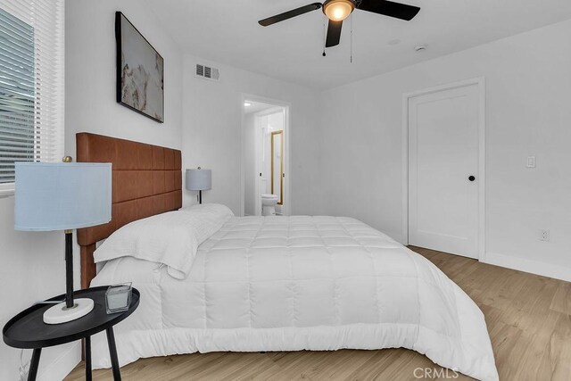 bedroom with wood finished floors, connected bathroom, and ceiling fan