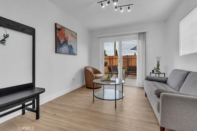living area featuring light wood-style flooring and baseboards