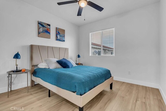 bedroom with baseboards, wood finished floors, and a ceiling fan