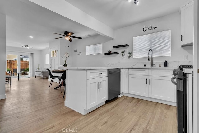 kitchen featuring a sink, electric range oven, dishwasher, white cabinets, and light wood-type flooring
