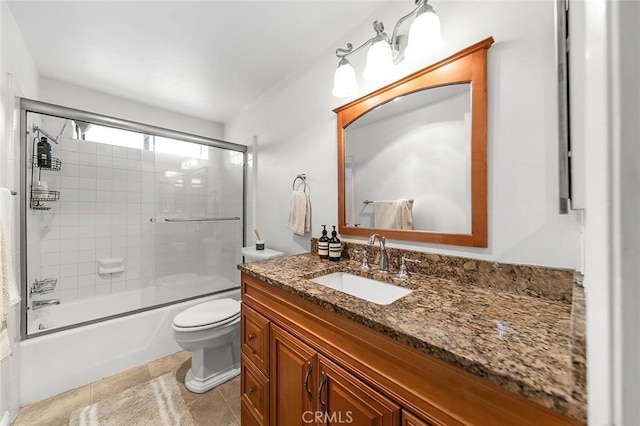 bathroom with toilet, vanity, and combined bath / shower with glass door