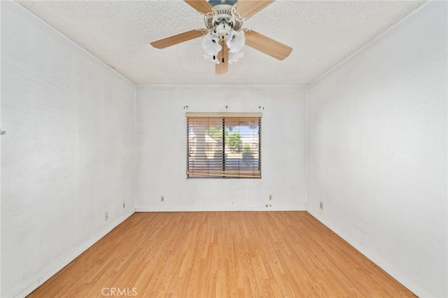 spare room with light wood-style floors, a textured ceiling, a ceiling fan, and baseboards