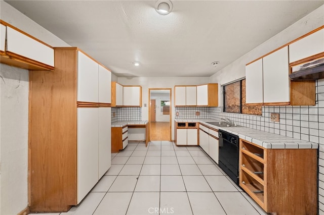 kitchen featuring dishwasher, decorative backsplash, white cabinets, and a sink