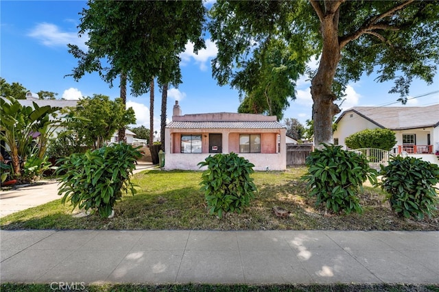 view of front of property with a chimney, stucco siding, and a tile roof