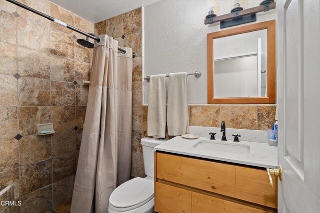 1037 Cortina Ct, Orland, CA 95963 - full bath featuring toilet, tiled shower, vanity, and tile walls