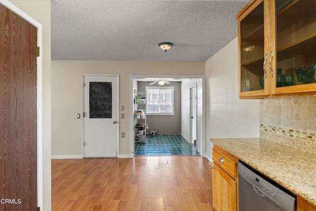 1037 Cortina Ct, Orland, CA 95963 - kitchen featuring dishwasher, tasteful backsplash, light wood-type flooring, glass insert cabinets, and a textured ceiling